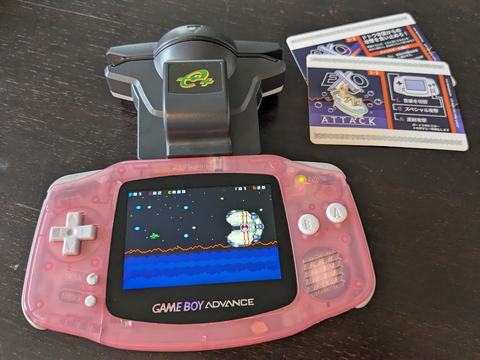 A Game Boy Advance playing Exo Attack with a Japanese E-Reader and Japanese cards nearby